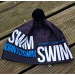 Winter cap black BornToSwim® with blue logo and black pompom